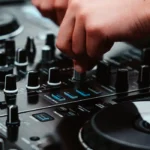 A person is using the knobs on a dj controller.