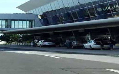 A large building with cars parked on the side of it.