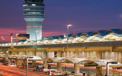 A large airport terminal with an air traffic control tower.