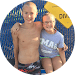 Two kids posing for a picture in front of a yellow sign.