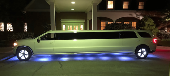 A white limo parked in front of a building.