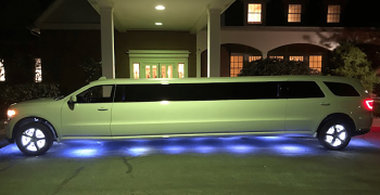 A white limo parked in front of a building.