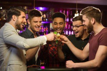 A group of men are toasting with drinks.